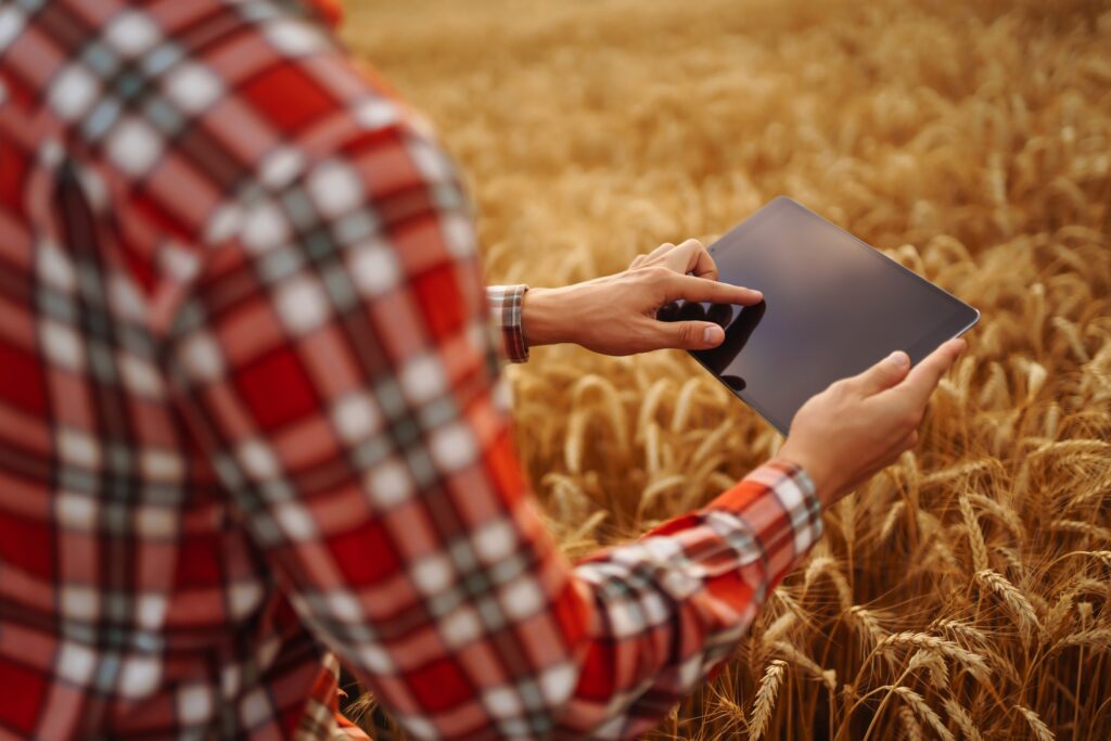 Tablet in the hands of a farmer. Smart farm. Farmer checking his crops on field.